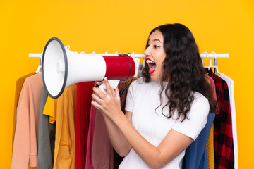 Wall Mural - Mixed race woman in a clothing store and holding a megaphone