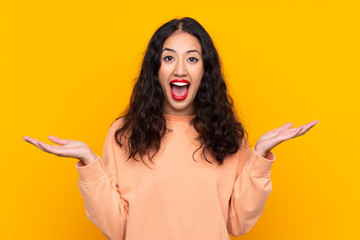 Canvas Print - Spanish Chinese woman over isolated yellow background with shocked facial expression