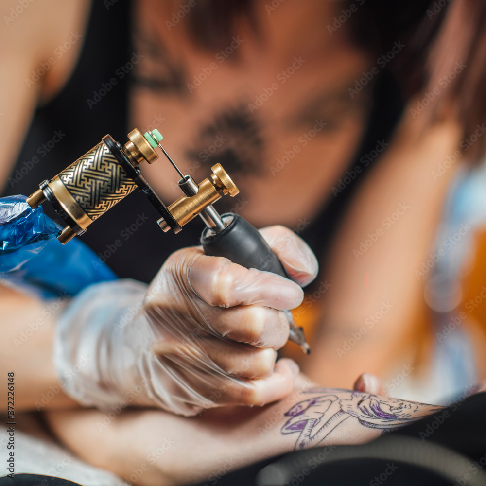 Foto Tattoo Machine Close Up. Tattoo Artist Creating Tattoo