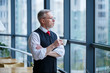 © Дмитрий Ткачук - Smiling happy managing director thinks about his successful career development while standing with a cup of coffee in his hand in his office near the background of a window with copy space