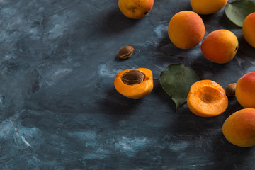 Ripe juicy orange apricots on a blue concrete background, view from above. Copy space.