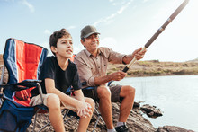 Latin Grandfather And Grandson Enjoying Day Together Fishing On The Lake