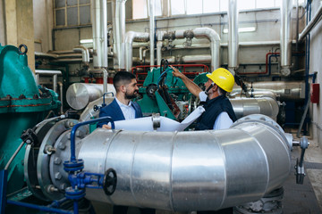 Wall Mural - worker in protective equipment and businessman working indoor in industry plant