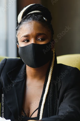 Cuadros en Lienzo An outdoor portrait of a young African female with chestnut braids and in a viru