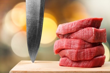 Wall Mural - Raw meat slices and knife on cutting board