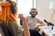 © Svitlana - Male blogger, man in headphones talking to woman while recording conversation, interview with her for video blog