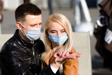 Young couple in love in protective medical mask on face outdoor at street. Environmental pollution concept. Guy and girl in virus protection