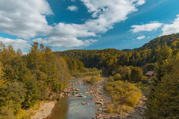 Wall Mural - rural mountain forest wilderness landscape scenic view from above in autumn clear weather day time highland rocky river lonely wooden cottage