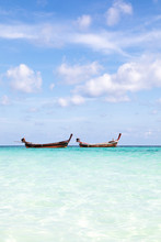 Two Long Tail Boats Floating On Turquoise Sea
