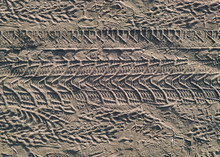 Tread Marks From Car And Bicycle Wheels On A Dirt Road Made Of Sand. View From Above.