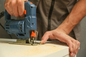 Wall Mural - refurbishment in the apartment. carpenter's hands are sawing with electric jigsaw