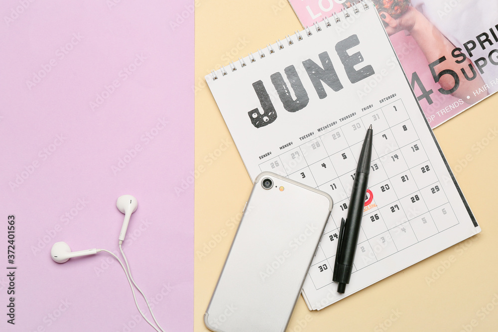 Mobile phone with calendar and magazine on color background