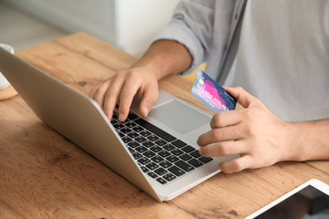 Wall Mural - Man with laptop booking tickets online at home