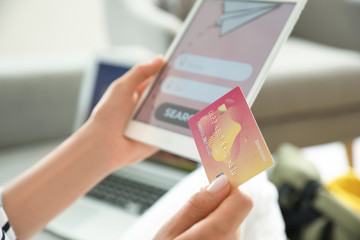 Poster - Woman with tablet computer booking tickets online at home