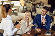 © Drazen - Cheerful business colleagues making an order in a cafe.