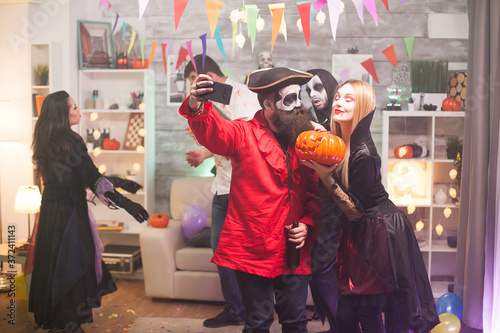 Fotografía Bearded medieval pirate taking a selfie with beautiful vampire woman at halloween party