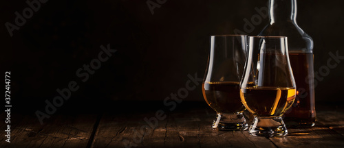 Fotomural Scotch Whiskey without ice in glasses and bottle, rustic wood background, copy s