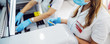 © Dusan Petkovic - Lab assistants putting test tubes with blood samples into machine while standing in laboratory.