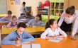 © JackF - Woman teacher helping to children 9-10 years old at lesson.