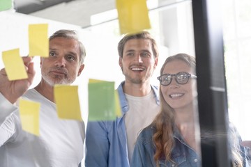 Wall Mural - Business people meeting at office and use post it notes to share idea. Brainstorming concept. Sticky note on glass wall.