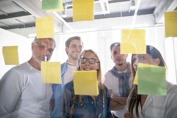 Wall Mural - Business people meeting at office and use post it notes to share idea. Brainstorming concept. Sticky note on glass wall.