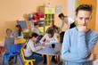 © JackF - Portrait of upset boy in schoolroom on background with pupils studying with teacher