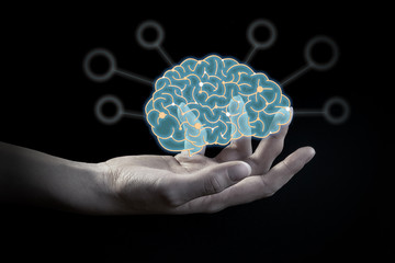 The businessman's hand holds an abstract polygonal brain with icons on a dark background. The concept of artificial intelligence, innovative technology