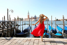 Holidays In Venice. Back View Of Beautiful Girl In Red Dress Enjoying View Of Venice Lagoon With The Island Of San Giorgio Maggiore And Gondolas Moored.