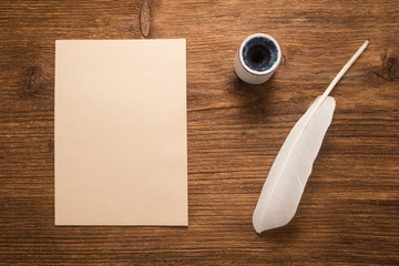 Wall Mural - Paper, goose feather, inkwell on a wood table  	