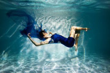 Wall Mural -  Woman in blue dress under water.