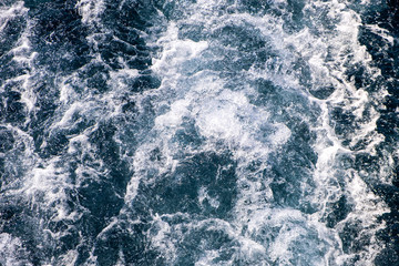 Top down aerial view of sea water surface. White foam waves texture as natural background.