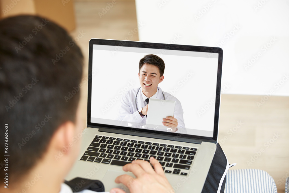 young asian man receiving a diagnosis using tele-medicine network - obrazy, fototapety, plakaty 