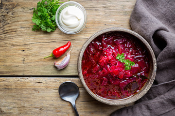 Wall Mural - Traditional Ukrainian Russian vegetable beet soup, borscht on wooden background, top view