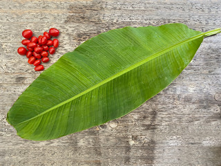 cherry tomatoes on wooden table with banana leaf