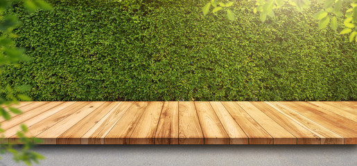 Wall Mural - Empty old wooden table or counter with green leaves background. For display or montage your products.