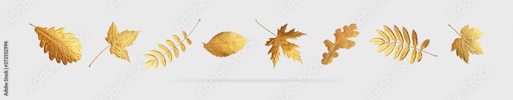 Golden flying autumn leaves of different shapes on light gray background. Autumn concept, fall background. Minimal floral design, autumn leaf frame. Golden twig. Autumn creative composition - obrazy, fototapety, plakaty 