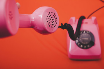  Vintage pink telephone with orange background