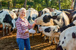 © JENOCHE - Farmer woman is working on farm with dairy cows