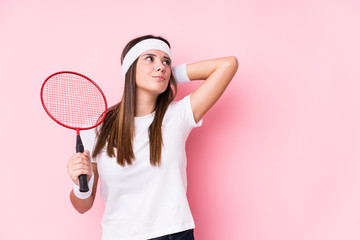 Wall Mural - Young caucasian woman playing badminton isolated touching back of head, thinking and making a choice.