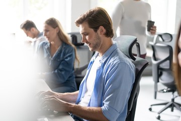 Wall Mural - Team Working At Desks In Busy Office