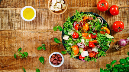 Wall Mural - Fresh vegetable salad on vintage wooden table, top view. Healthy eating and lifestyle.