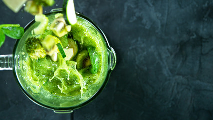 Green fresh smoothie blended in blender, top view. Healthy eating concept.