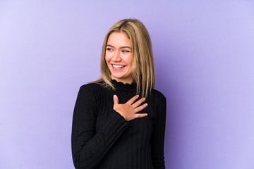 Wall Mural - Young blonde caucasian woman isolated laughs out loudly keeping hand on chest.