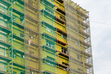 Wall Mural - scaffolding arround the house to install thermal insulation of the apartment building facade