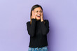 © Asier - Young woman isolated on purple background covering ears with hands trying not to hear too loud sound.