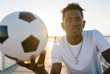 Close-up Of Young Man Holding Soccer Ball Against Clear Sky During Sunny Day