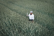 © Epiximages/Westend61 - Drone shot of man holding small windmill while standing amidst cornfield