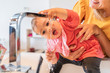 © Juan Miguel Aparicio/Westend61 - Close-up of mother holding cute baby girl drinking water through faucet in kitchen sink