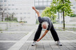 © Eugenio Marongiu/Westend61 - Senior man exercising while standing on footpath against building in city