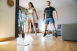 © Mikel Taboada Blanco/Westend61 - Couple jumping while exercising on hardwood floor at home